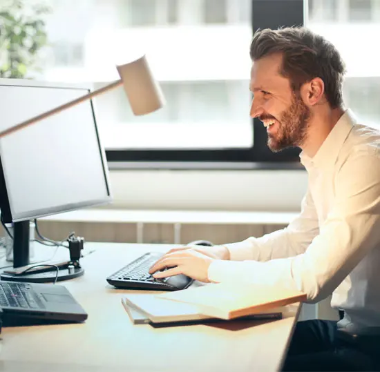 IT Specialist Working on Computer With Smile